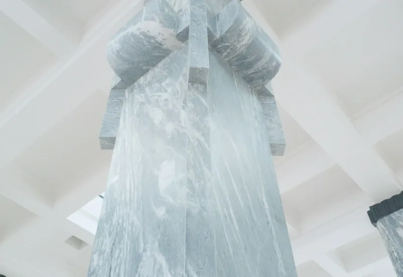 Translucent plastic sheeting hanging in loose folds from a white ceiling, screening off the space behind it.